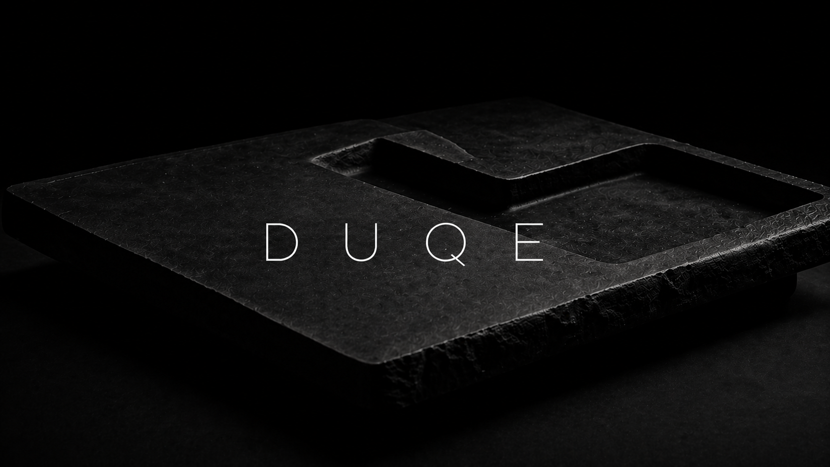 Dark stone surface with 'DUQE' branding in white text